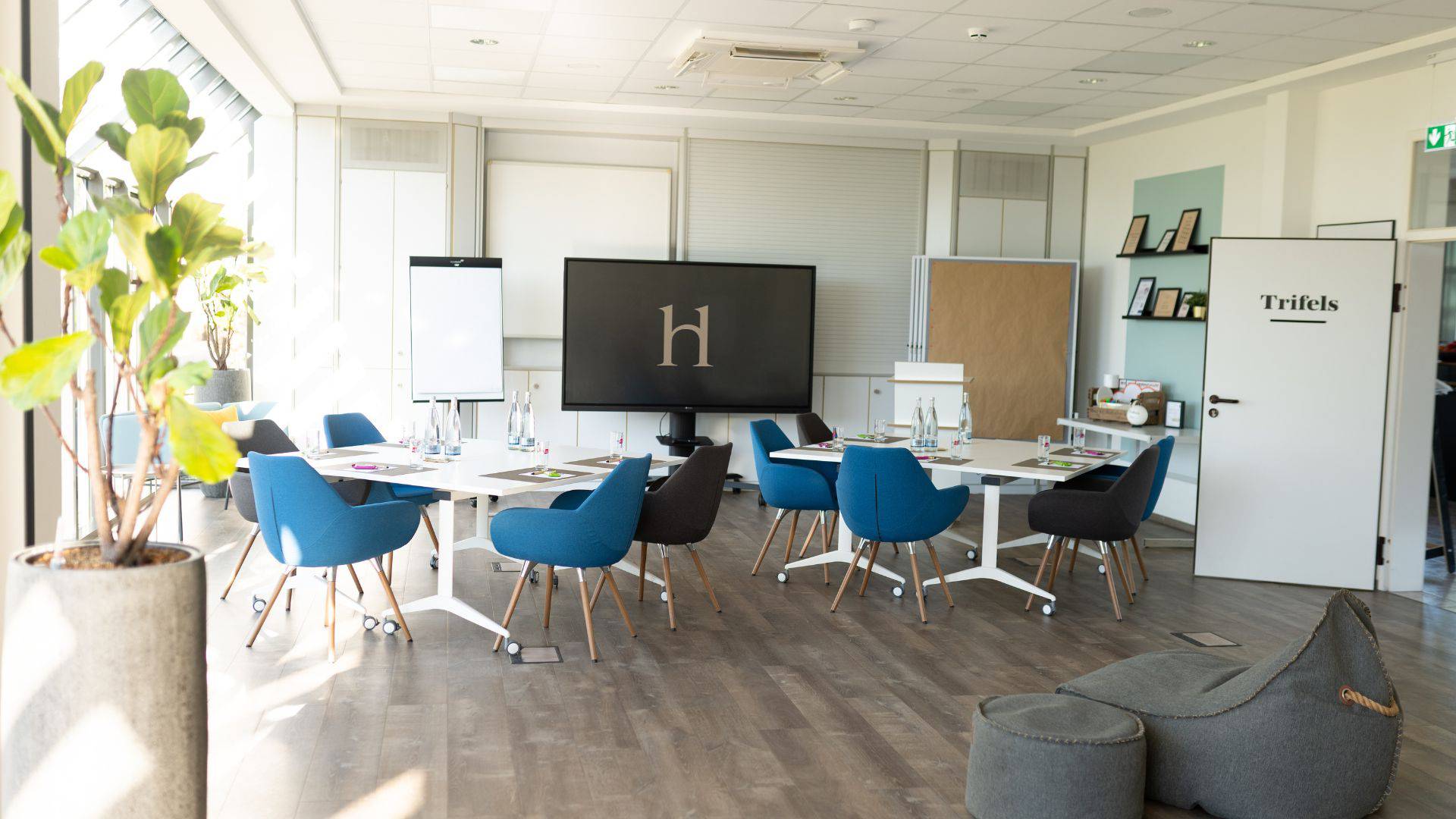 Tagungsraum Trifels im Leinsweiler Hof mit freier Bestuhlung und Präsentationsscreen für Workshops und Meetings in der Südpfalz.