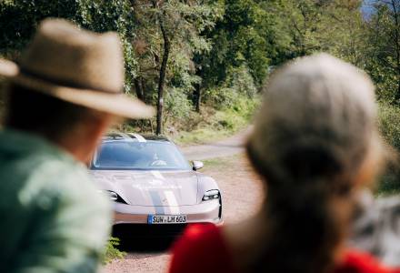 Sportwagen auf Waldparkplatz zwischen Bäumen aus der Perspektive von zwei Personen im Vordergrund unterwegs beim Aktivurlaub im Schwarzwald.